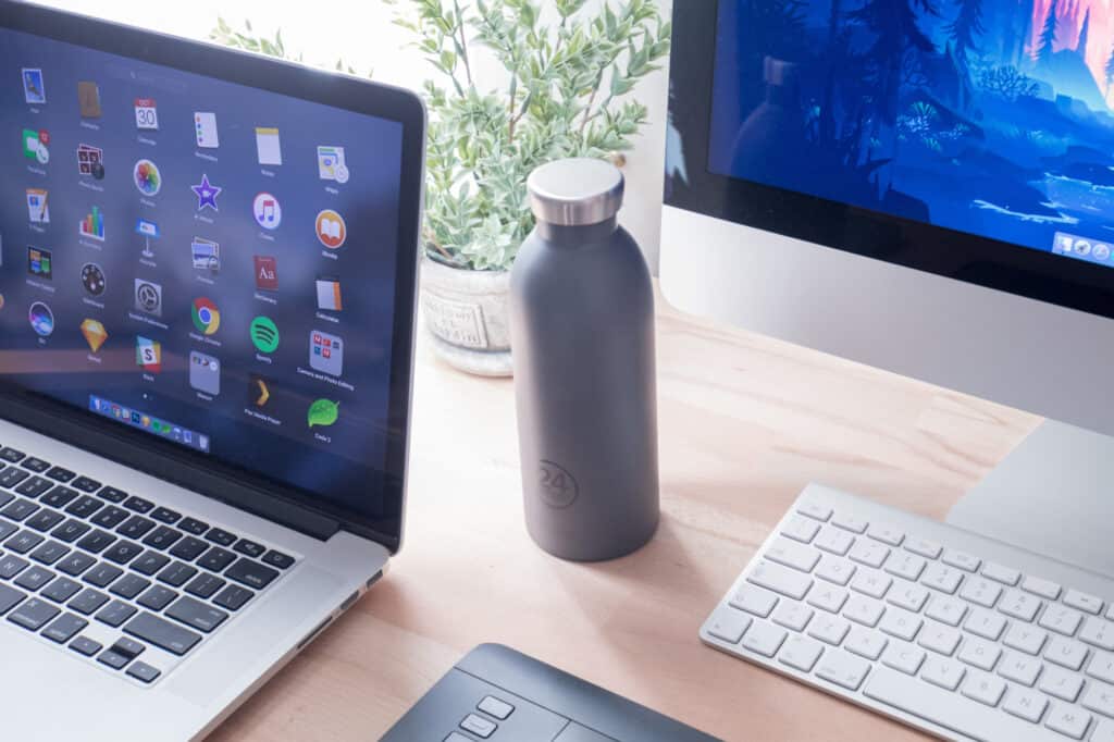 Water bottle on desk by laptop and desktop